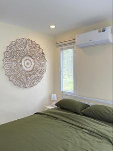 a bedroom with a bed and a clock on the wall at Bright Sanctuary in Ko Phangan