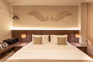 ein Schlafzimmer mit einem großen Bett mit zwei Flügeln an der Wand in der Unterkunft Baliris Home Boutique Legian in Seminyak