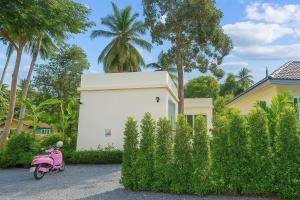 a pink scooter parked in front of a house at Bright Sanctuary in Ko Phangan