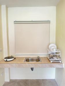 a kitchen counter with a sink and some dishes at Bright Sanctuary in Ko Phangan