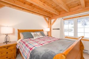 ビッグ・ホワイトにあるAlpine Timbers 2 Luxury Chalet with Hot Tubの木製の天井が特徴のベッドルーム1室(ベッド1台付)