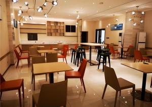 City Comfort Inn Mianyang Southwest University Of Science And Technology في Qinglianchang: مطعم به طاولات وكراسي في غرفة