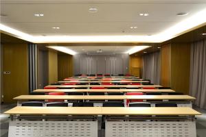 an empty lecture room with rows of tables and chairs at City Comfort Inn Jinan Railway Station Daming Lake in Jinan