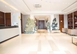 a lobby of a building with sculptures on the walls at City Comfort Inn Nanning Chaoyang Square Theater Metro Station in Nanning