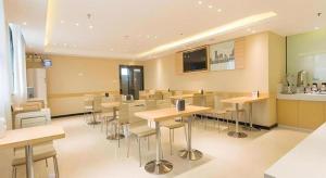 a room with tables and chairs in a restaurant at City Comfort Inn Nanning Chaoyang Square Theater Metro Station in Nanning