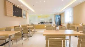 a restaurant with tables and chairs and a counter at City Comfort Inn Nanning Chaoyang Square Theater Metro Station in Nanning