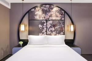 a bedroom with a large white bed with a floral wall at Crystal Orange Hotel - Shanghai The Bund Jinling East Road in Shanghai
