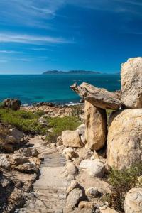 un camino de piedra junto al océano en un acantilado en Pet Friendly Sleeps 8 Bowen Holiday House, en Bowen