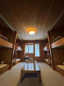 a room with a table in a room with bunk beds at 安比高原ロッジタンデム in Wada
