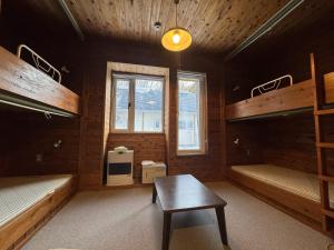 a room with two bunk beds and a table in it at 安比高原ロッジタンデム in Wada