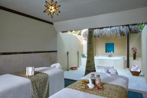 a room with two beds and a bathroom with a sink at Taj Exotica Resort & Spa, Maldives in South Male Atoll +51 photos