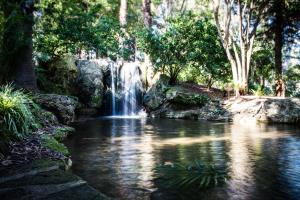 a waterfall in front of a pool of water at Como Retreat - two bedroom villa in Perth