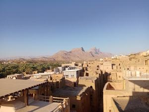 Blick auf eine Stadt mit Bergen im Hintergrund in der Unterkunft Blue star inn in Al Hamra