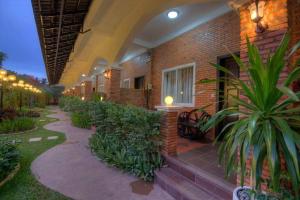 a building with a courtyard with plants in front of it at Kravan Siem Reap Boutique Villa in Phumĭ Kruŏs
