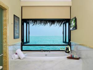 a bathroom with a tub with a large window at Taj Exotica Resort & Spa, Maldives in South Male Atoll