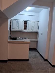 een keuken met witte kasten en een aanrecht in een kamer bij Ceylonza Deluxe in Nikawatawana