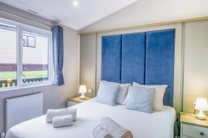 a bedroom with a large white bed and a window at Lodge 71 at Riviera Bay Coastal Retreat in Brixham +38 photos