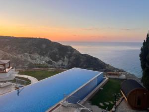 a large swimming pool with a view of the ocean at Matteo Villa Limassol Cyprus in Limassol