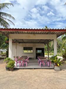 a pavilion with pink tables and chairs on it at Kohmook Timberland Resort from Seaview in Koh Mook