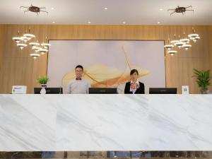 two people are standing behind a large white table at Green Tree Inn Express Fuzhou Three Lanes and Seven Alleys Nanmendou Metro Station in Fuzhou