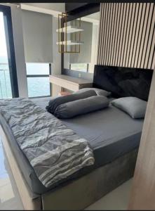 Delft Apartement Sunset CPI Makassar في Tanjungbunga: سرير كبير في غرفة نوم مع نافذة كبيرة