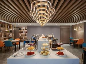 Gya Hotel Chengdu Global Center Jinchenghu Metro Station في تشنغدو: بوفيه على طاولة في مطعم