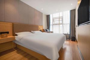 Gya Hotel Chengdu Global Center Jinchenghu Metro Station في تشنغدو: سرير أبيض كبير في غرفة فندق +215 صورة