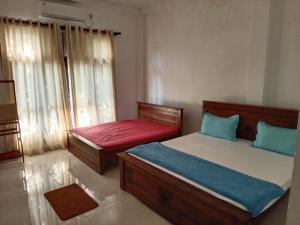 a bedroom with two beds and a window at Bosadi Apartment katunayaka in Katunayaka