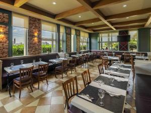 a restaurant with tables and chairs and windows at ibis Sorocaba in Sorocaba