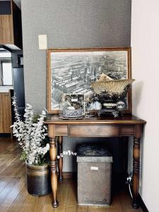 Maison Petit Lapin メゾンプチラパン في كارويزاوا: طاولة خشبية مع لوحة على الحائط