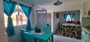 tavolo e sedie in cucina con tende blu di La Morada a Gaiman