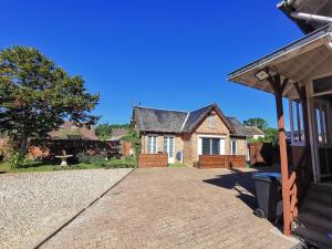 a brick house with a roof and a driveway at A l'étoile du soir in Nançay