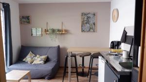 a living room with a blue couch and a table at A l'étoile du soir in Nançay