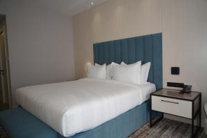 a bedroom with a large white bed with a blue headboard at Azure Resort in Chimgan +51 photos