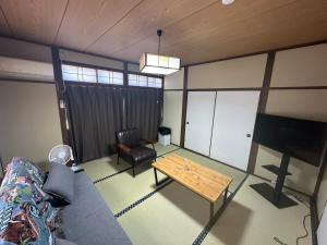ein Wohnzimmer mit Sofa und Tisch in der Unterkunft MIYABI stay house in Tamana