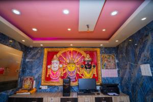 Shreekrishna Hotels & Resorts Pvt Ltd في كولْكاتا: غرفة بها لوحة لآلهة على الحائط