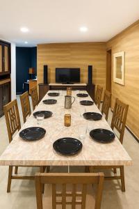 een grote houten tafel met stoelen en een eetkamer bij Secret Escape Heritage Bungalow in Ooty