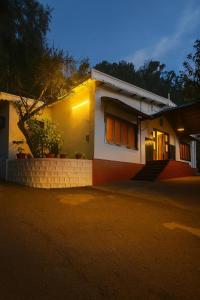 een huis 's nachts met de lichten aan bij Secret Escape Heritage Bungalow in Ooty