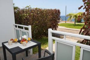 Apt. El Guirre Nº 8 - bajo في La Playa Calera: طاولة مع مشروبات وفواكه على شرفة