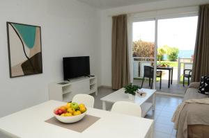 Apt. El Guirre Nº 8 - bajo في La Playa Calera: غرفة معيشة مع وعاء من الفواكه على طاولة