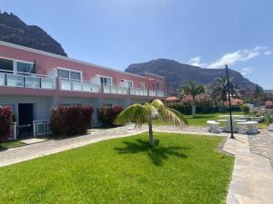 Apt. El Guirre Nº 8 - bajo في La Playa Calera: نخلة أمام المبنى