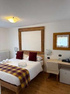 um quarto de hotel com duas camas e uma escrivaninha e uma escrivaninha em Hotel Ambassador Bormio em Bormio mais 6 fotografias