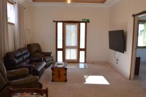 a living room with a couch and a flat screen tv at Norseman AirbnbAngels Place in Norseman