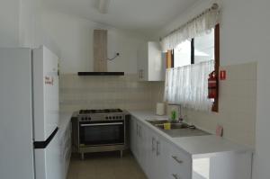 a white kitchen with a stove and a sink at Norseman AirbnbAngels Place in Norseman +4 photos