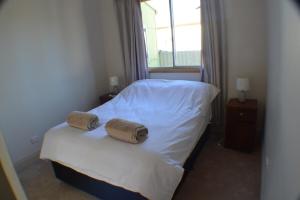 a bedroom with a bed with two towels on it at Norseman AirbnbAngels Place in Norseman