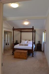 a bedroom with a large bed with a wooden frame at Norseman AirbnbAngels Place in Norseman
