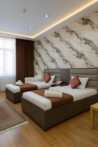 杜尚别Vatan Hotel的房间里有两张床，墙上有一幅壁画 更多5张照片