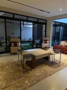 un soggiorno con tavolino e sedie. di شاليه لوسيندا a Baljurashi