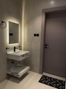 un bagno con lavandino, specchio e porta di شاليه لوسيندا a Baljurashi Altre 9 foto