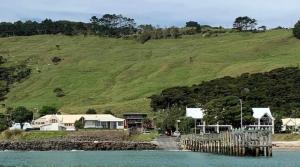 a house on the shore of a body of water at Beach view studio 337 in Omapere